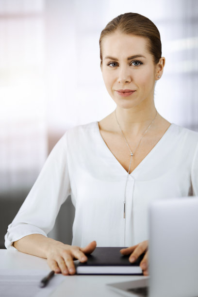 女商人坐在阳光明媚的办公室里看着摄像机图片下载