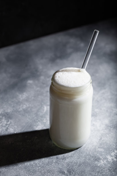 艾兰土耳其起泡酸奶饮料在玻璃罐与稻草在灰色的背景图片下载