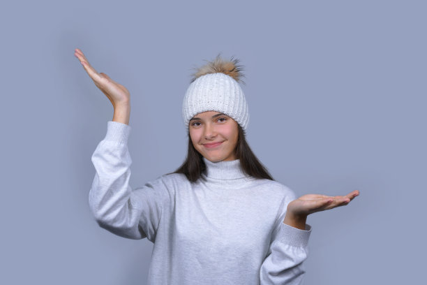 年轻女孩穿着暖和的套衫，戴着帽子图片下载