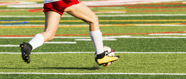 女足球运动员在场上带球时的双腿图片下载