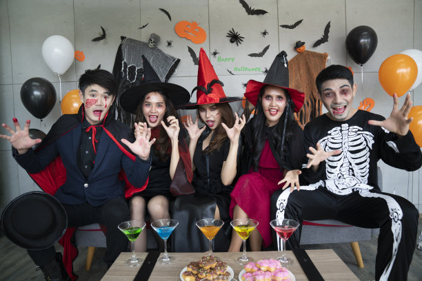 年轻的亚洲人，五个人一组，穿着可怕的服装。一群穿着万圣节服装的朋友准备参加一个聚会。图片下载