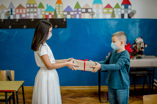 学校的孩子们在教室里庆祝新年。他们戴着防护口罩。图片下载