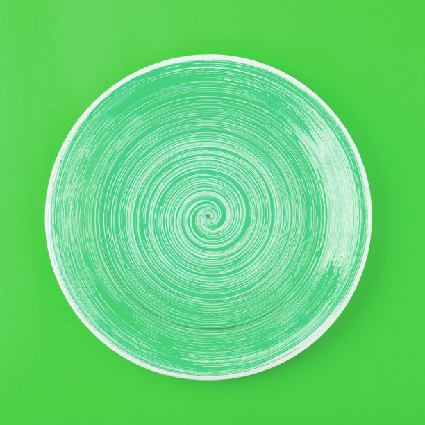 石灰色圆板在饱和的绿色背景图片下载