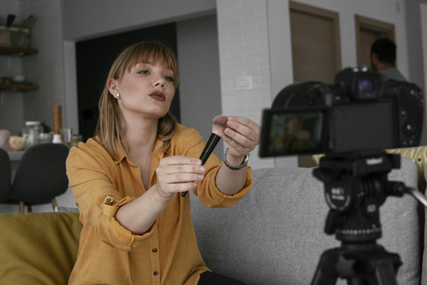 年轻美丽的女人录制化妆教程分享在社交媒体上。图片下载