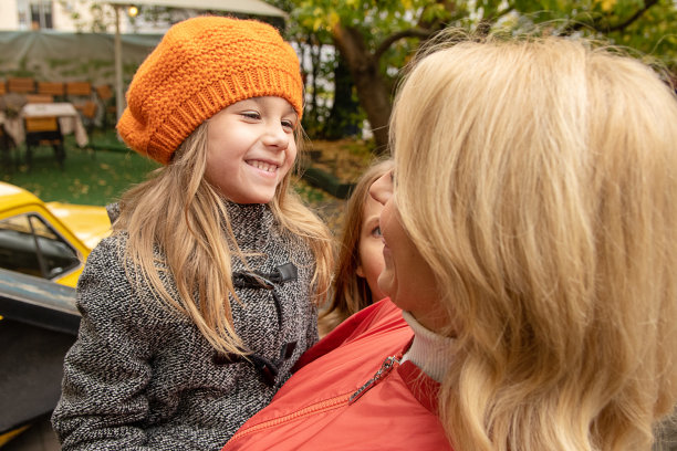 穿着秋装的女人和可爱的小女孩玩得很开心。妈妈，小女儿在花园外面。母亲节爱家庭，为人父母童年观念。照片图片下载