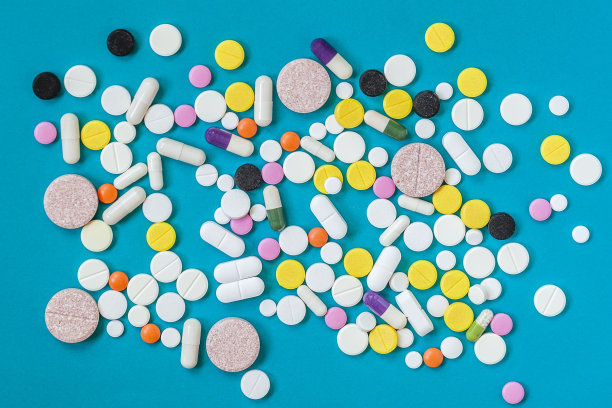 不同种类的药片，不同的颜色和大小，在蓝色的背景上。俯视图，平放图片下载