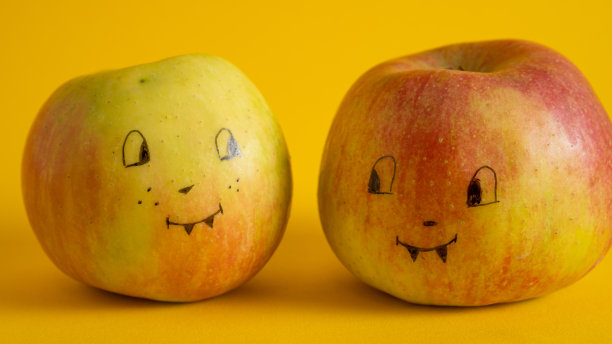 黄色背景上苹果上画的脸。苹果杰克作为万圣节杰克的替代品。有趣的孩子图片下载