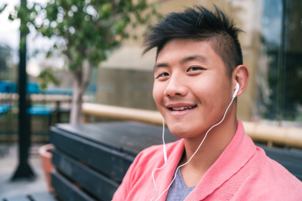 亚洲男人用耳机听音乐。图片下载