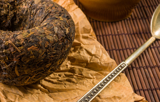 中国压普洱茶的包装纸和茶的附件在竹席上，特写，宏观图片下载