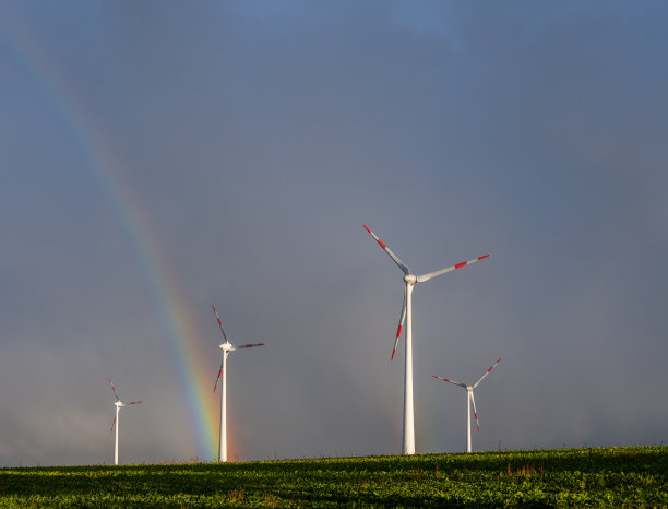 巨大的彩虹在风力涡轮机所在的土地上图片下载