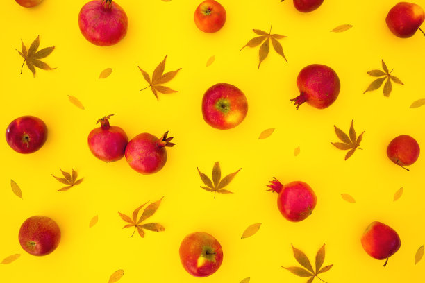 图案的石榴果实与秋叶孤立在明亮的黄色背景。平躺，俯视图图片下载