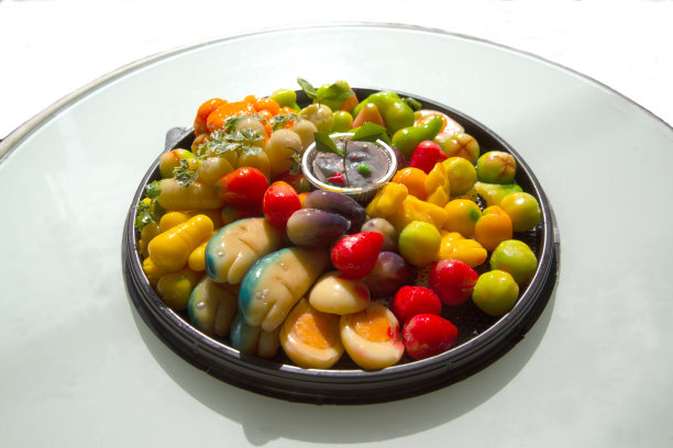 水果形状像一个透明的玻璃，内部是由坚果果冻，模仿水果。是一道传统的泰国甜点，以白色为背景。图片下载