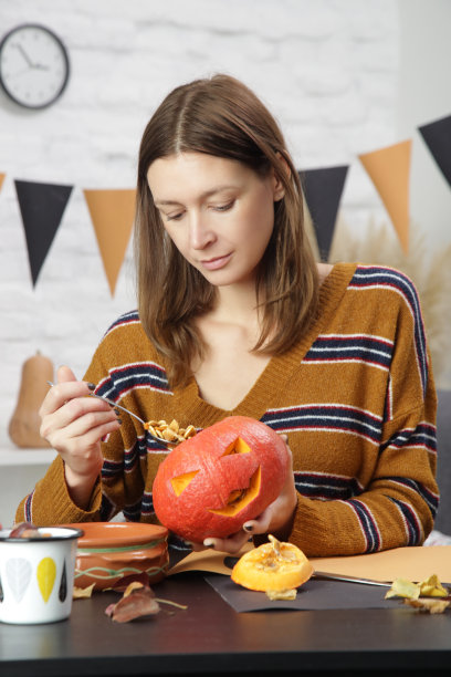 年轻女子在家制作万圣节装饰。秋季DIY工艺。图片下载