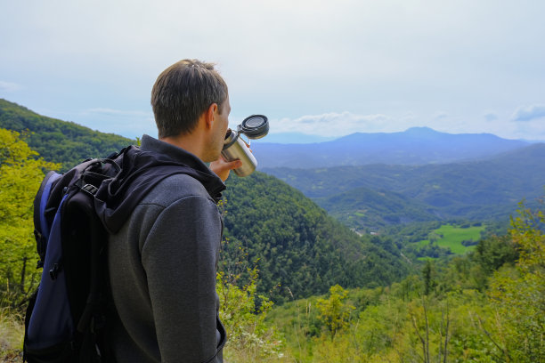 天啊，徒步旅行者在山里喝热水瓶里的饮料。与背包旅行者。徒步旅行的设备。自然背景。副本的空间。高质量的照片图片下载