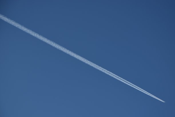 一架飞机飞过蓝天。喷气式飞机在蓝天上飞行。飞机飞越蓝天。图片下载