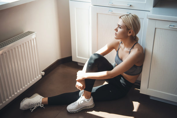 年轻的白种人健身妇女在运动装是有一个休息从锻炼放松在地板上图片下载