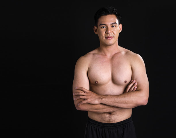 亚洲肌肉男子站在黑色背景的肖像图片下载