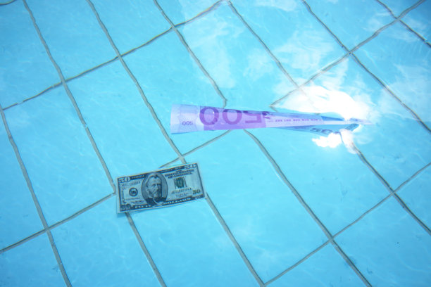 欧元和美元钞票在清澈的蓝色海水上游泳图片下载
