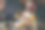 漂亮的女人穿着暖和的毛衣，袜子和圣诞帽，坐在家里的地板上拿着礼品盒图片下载