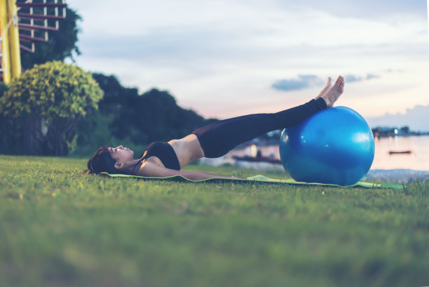剪影女子暑期在海滩上练习瑜伽，在泰国热带海滩旅游，度假和放松的概念图片下载