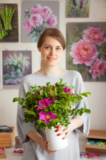迷人的微笑年轻的白人女艺术家持有一个花瓶图片下载