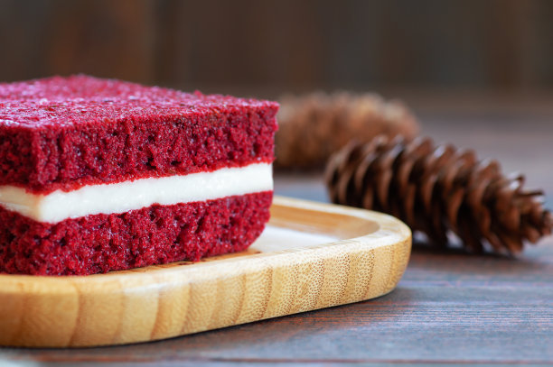 一块红丝绒蛋糕盘在质朴的桌子上，方形切片，复制空间选择性的焦点图片下载