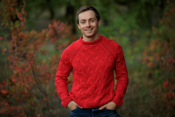 微笑的英俊男子在红毛衣图片下载