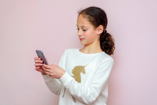 使用现代智能手机的年轻女孩，时尚儿童博主在手机上打字图片下载