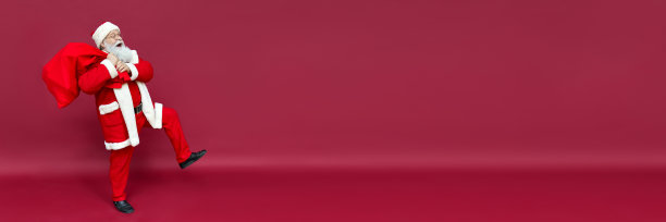 快乐风趣的圣诞老人拿着装满圣诞礼物的麻袋，在红色背景上行走送礼物图片下载