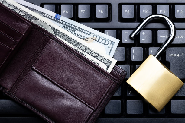 网上投资隐私概念。棕色皮夹和黑色键盘上的金色挂锁。以上的观点。影棚拍摄图片下载