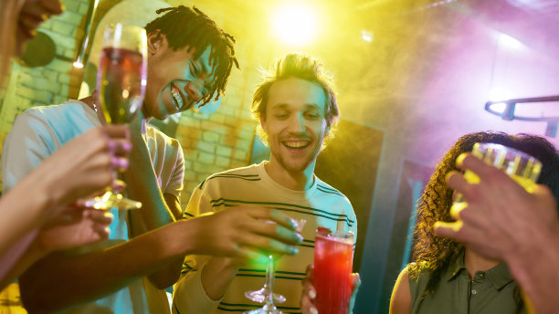今晚新政党。一群朋友，年轻的女人和男人祝酒，而有乐趣，喝鸡尾酒，花时间一起在夜总会图片下载