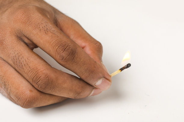 白色背景上，手里拿着燃烧的火柴图片下载