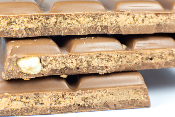 牛奶巧克力和坚果躺在白色的背景。近距离的照片。图片下载