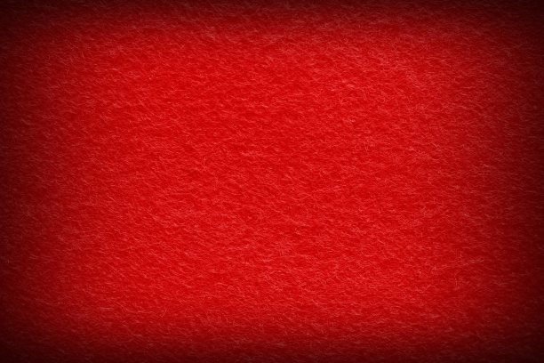 扑克桌毛毡织物纹理背景在红色与深色vignette。图片下载