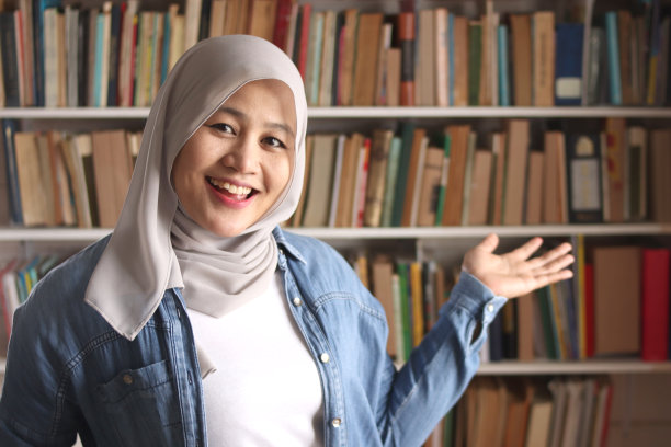 快乐的亚洲穆斯林女图书管理员戴着头巾微笑图片下载