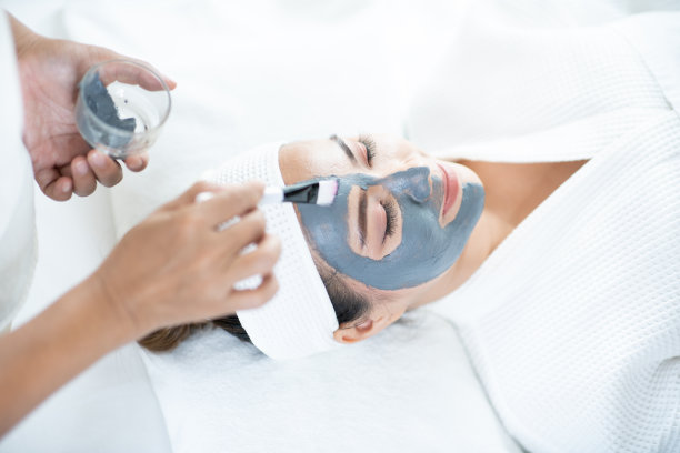 俯视图的脸皮肤护理。一名亚洲妇女在水疗沙龙里用面具蒙面。有美容spa面膜的女人。图片下载