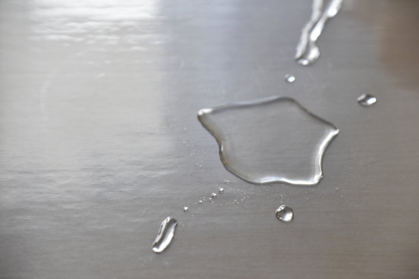 木桌上塑料布上的那滴不成形的水滴图片下载