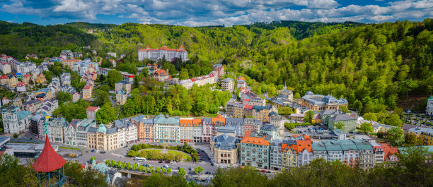 卡罗维发利市航拍全景，历史悠久的市中心有一排排色彩斑斓的建筑和水疗酒店。捷克共和国卡尔斯巴德镇和斯拉夫科夫森林山的全景图片下载