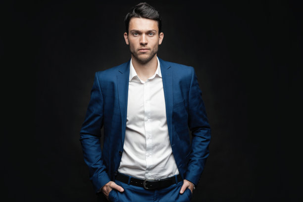 英俊的男子穿蓝色西装孤立在黑色背景。图片下载