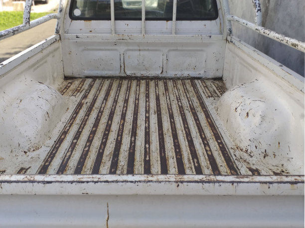 旧而生锈的车辆的空后备箱内部。在一辆生锈的空货车后面。白色皮卡上的空生锈后备箱后视图。图片下载