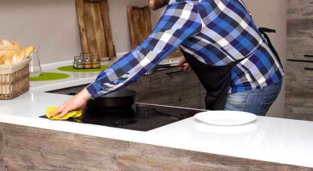 一个留着胡子的男人负责现代厨房的清洁，家庭清洁，家政图片下载