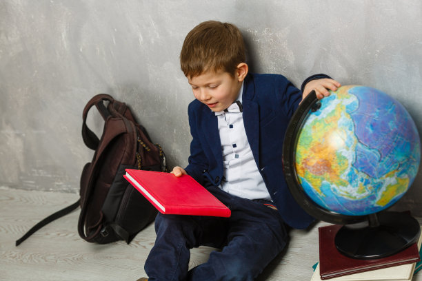 快乐可爱聪明的男孩戴着眼镜，书包和书。现代的背包。孩子已经准备好回答背景问题了。第一次上学。回到学校图片下载