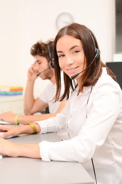 一群年轻人戴着耳机在台式电脑上工作，在客户服务呼叫支持热线业务中心工作图片下载