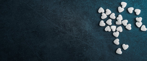 蓝色背景上的心形白色药丸。图片下载