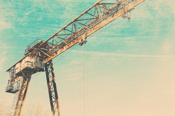 旧的，生锈的门式起重机在铁路上，一个废弃的混凝土工厂。危机、经济崩溃和生产能力的关闭导致了崩溃。全球灾难。一张古老照片的效果。图片下载