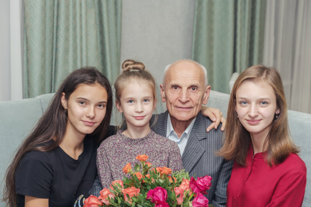 家人坐在家里捧着一束鲜花庆祝生日图片下载