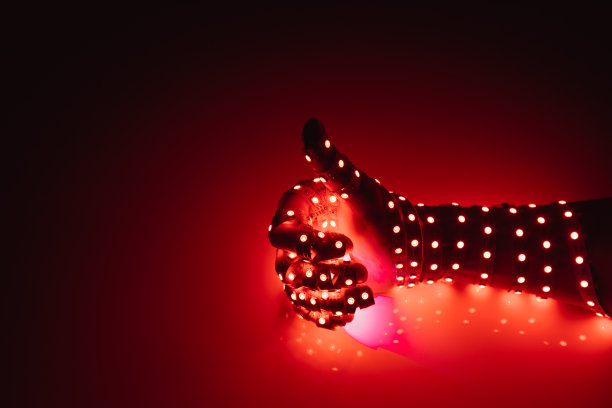 拇指向上的手覆盖着红色的led灯，照亮了背景图片下载