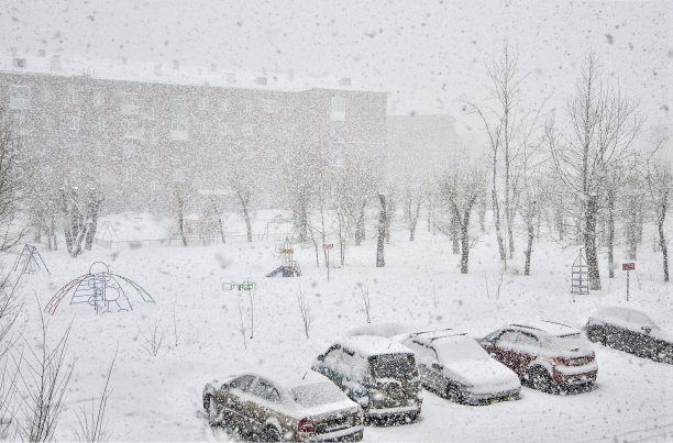 城里有大风雪。住宅区停车场被积雪覆盖的汽车图片下载