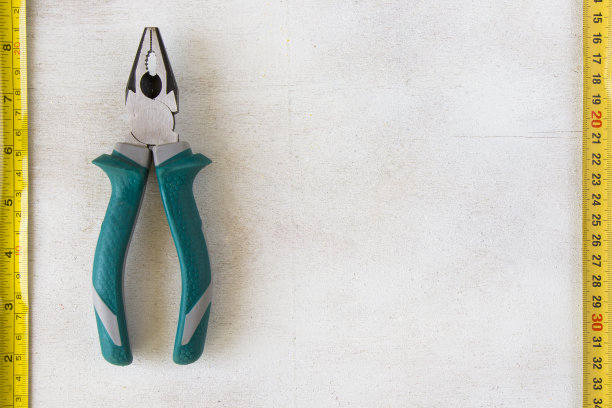 白色背景上的卷尺和钳子，建筑工具图片下载