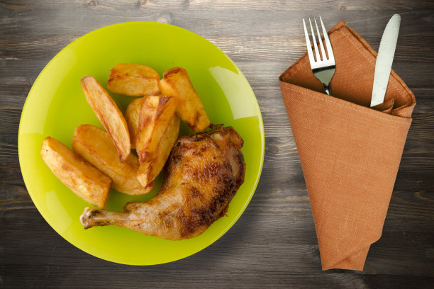 鸡腿配薯条，木质背景。图片下载